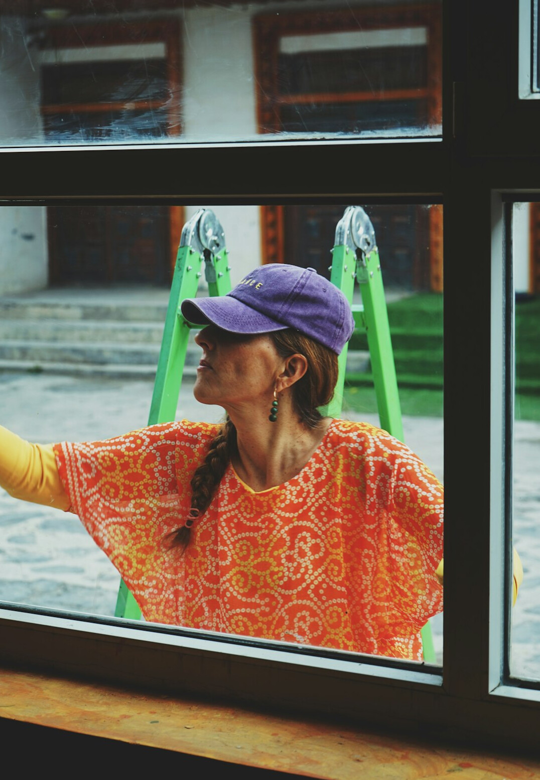 woman cleaning window with natural solution