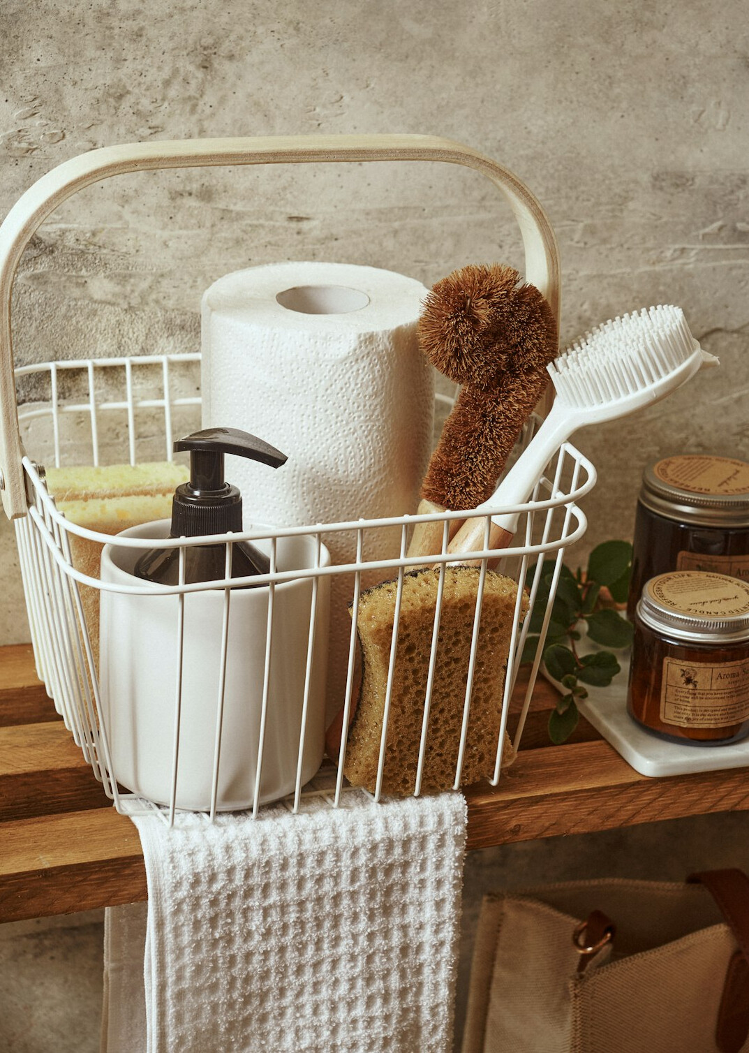 Cleaning supplies in a basket with cloths and spray bottle